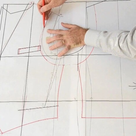 Corso Modellista Uomo Mani che tracciano a matita linee su un cartamodello per abbigliamento maschile